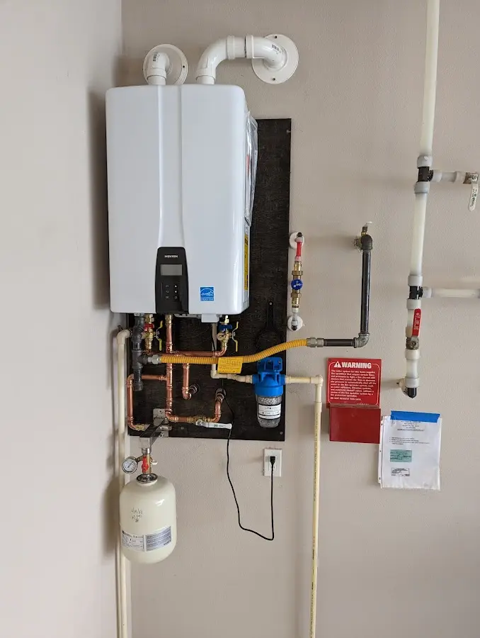 Professional plumber installing copper piping in a Bowne home